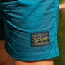 man walking at One Mile Sycamore Pool wearing Atlantic Pro Label Beach Shorts from Upper Park Clothing