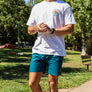 man walking at One Mile Sycamore Pool wearing a Freshwater Floating Club tee and Pro Label Beach Shorts from Upper Park Clothing