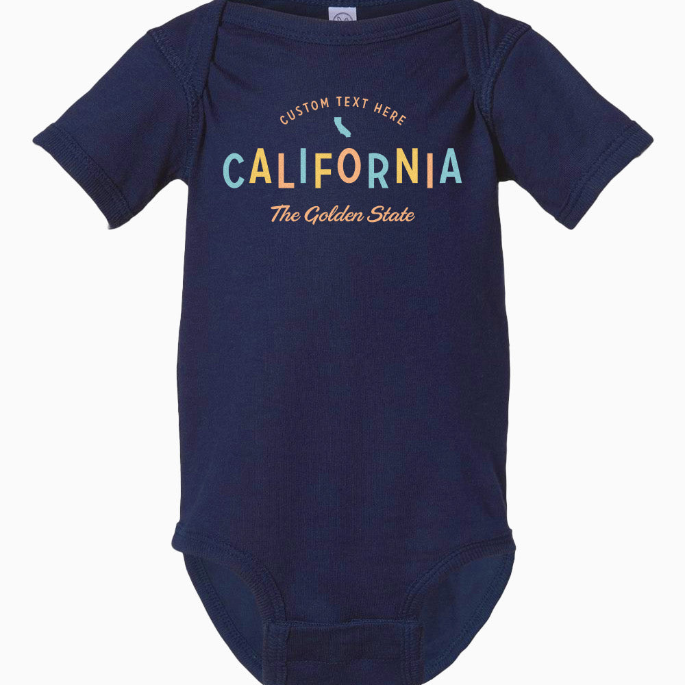 A navy blue baby onesie with the text 'CALIFORNIA THE GOLDEN STATE' printed across the front.