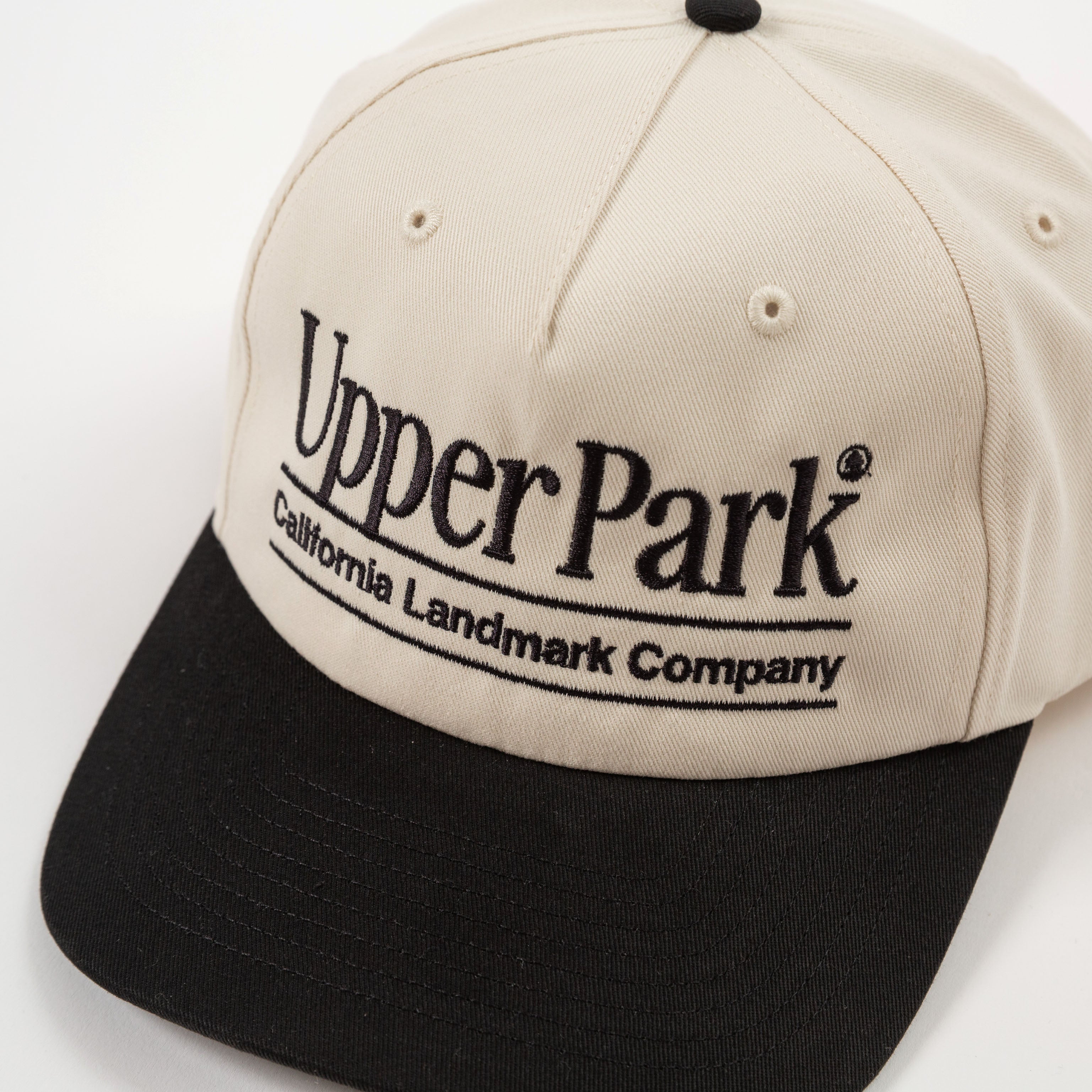 Detail cream and black cap with 'Upper Park' logo on a white background - California Landmark Company