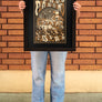 women standing in front of a brick wall in Downtown Chico holding a Caper Acres Playground Poster in a Frame from Upper Park Clothing