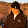 man leaning against a rail at Horseshoe Lake in Upper Bidwell Park wearing a workwear back from Upper Park Clothing