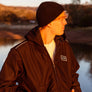 man leaning against a rail at Horseshoe Lake in Upper Bidwell Park wearing a workwear back from Upper Park Clothing