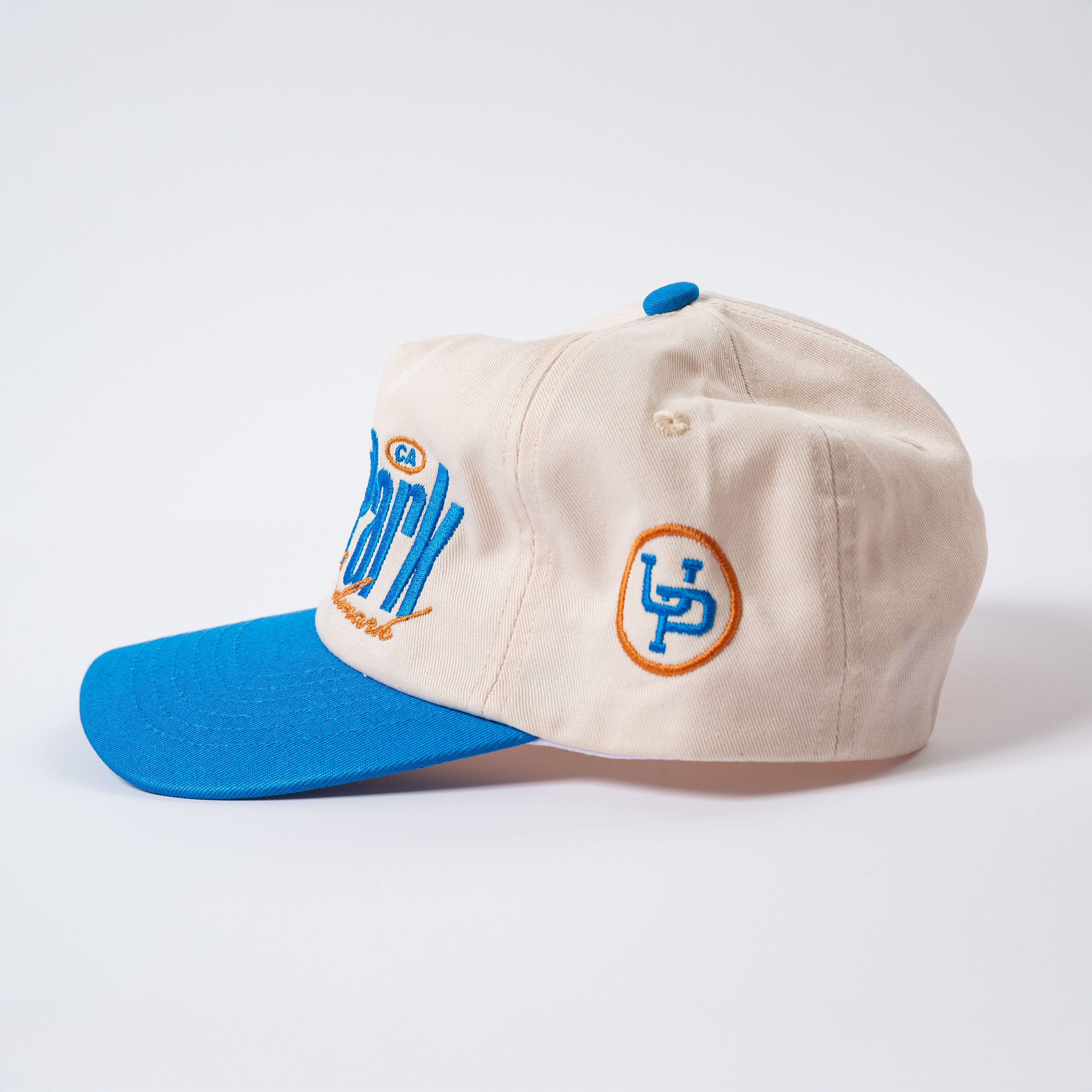 Beige cap with blue brim and logo on a white background - Rally Unstructured Vintage Style Hat