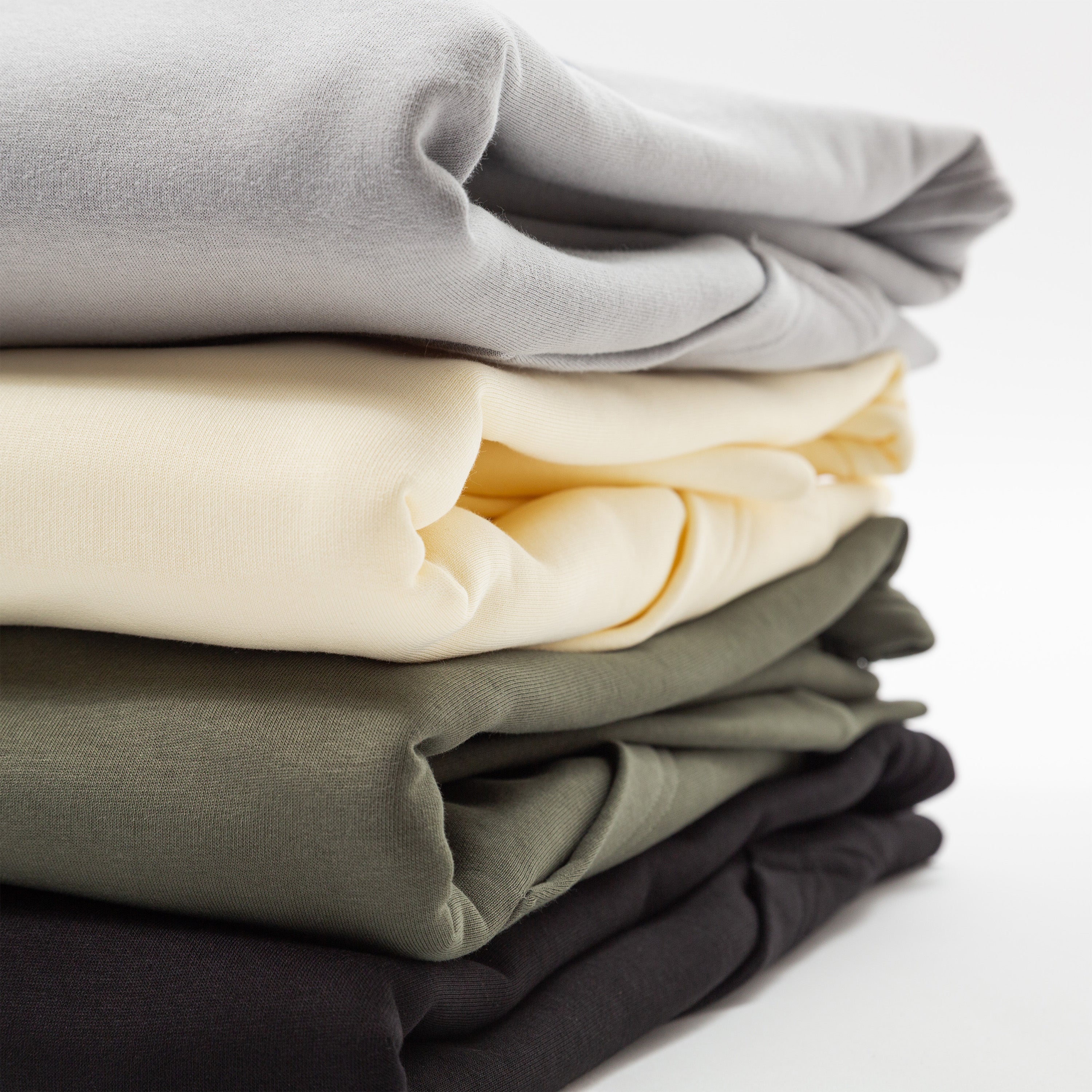 Stack of folded hoodies in gray, yellow, green, and black on a white background - Upper Park Athletics Hoodie Set