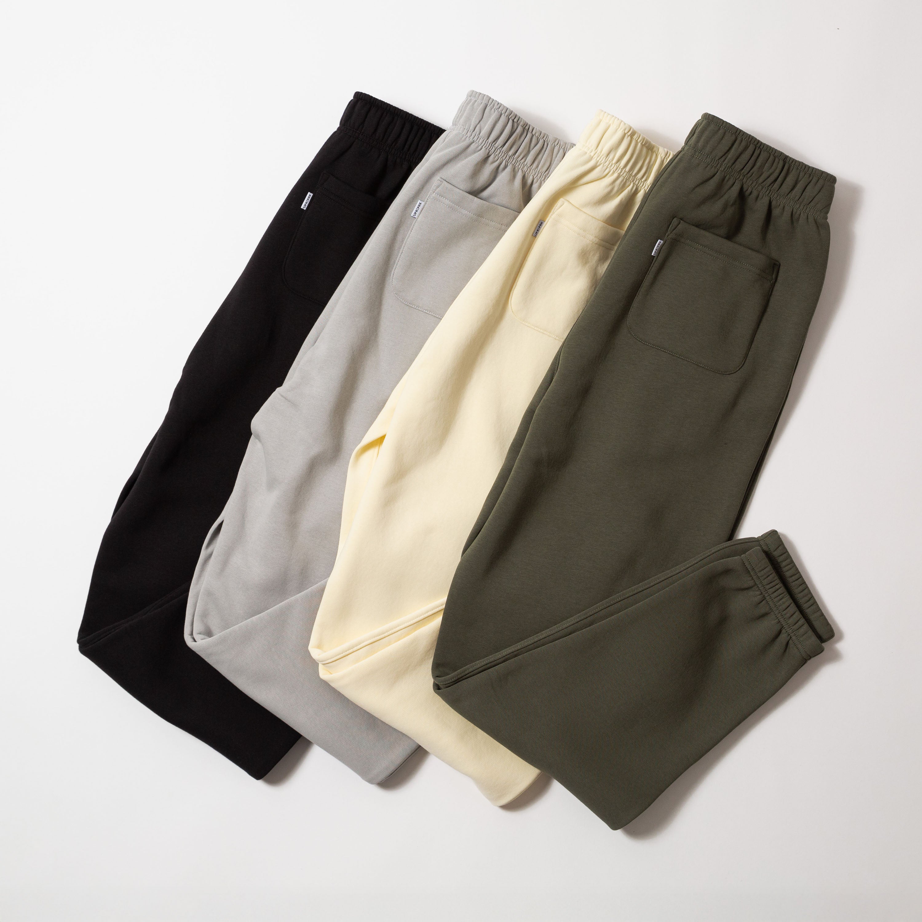 Four pairs of sweatpants in black, gray, yellow, and green on a light gray background - Upper Park Athletics Sweatpants Set