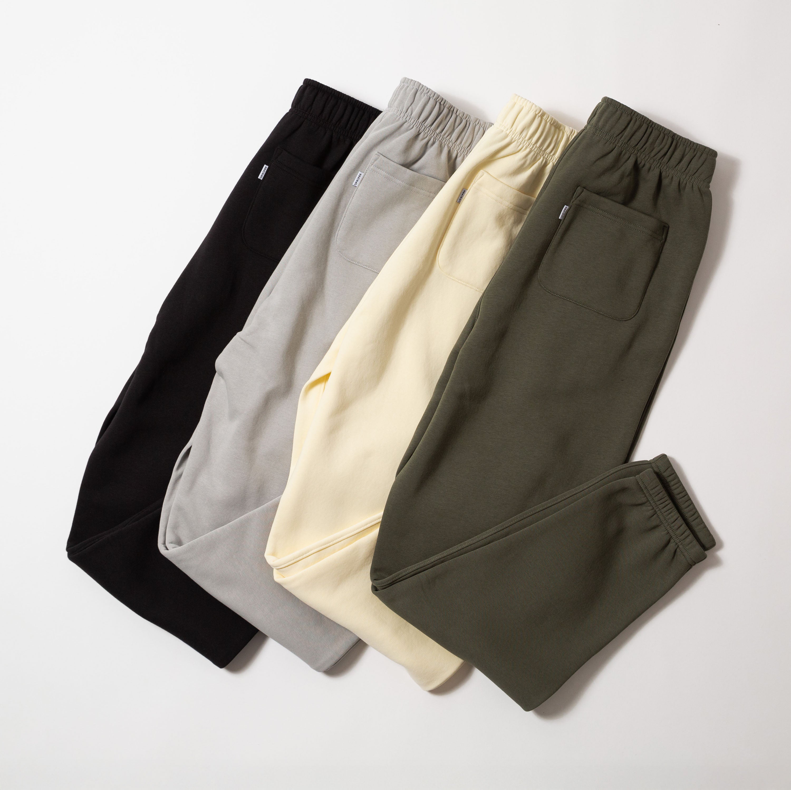 Four pairs of sweatpants in black, gray, yellow, and green on a light gray background - Upper Park Athletics Sweatpants Set