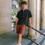 man standing on the stairs in front of the U.S Post Office in Downtown Chico wearing clay walk shorts from Upper Park Clothing