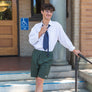 man standing on some stairs in Downtown Chico fixing his tie wearing walk shorts from Upper Park Clothing