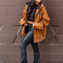 women standing in front of a blank wall in Downtown Chico wearing a workwear jacket from Upper Park Clothing