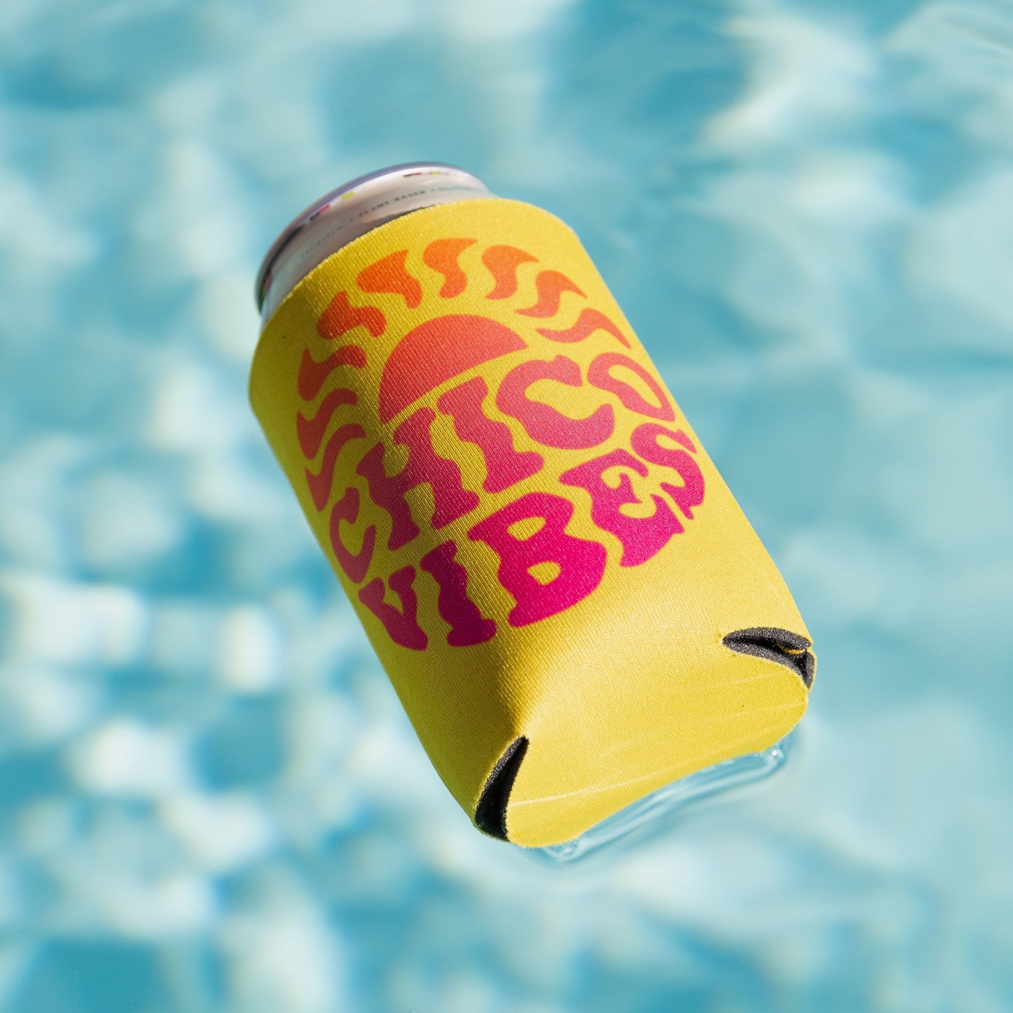 Yellow Chico Vibes Koolie Can Cooler floating in a pool - Upper Park Clothing - Chico, Ca