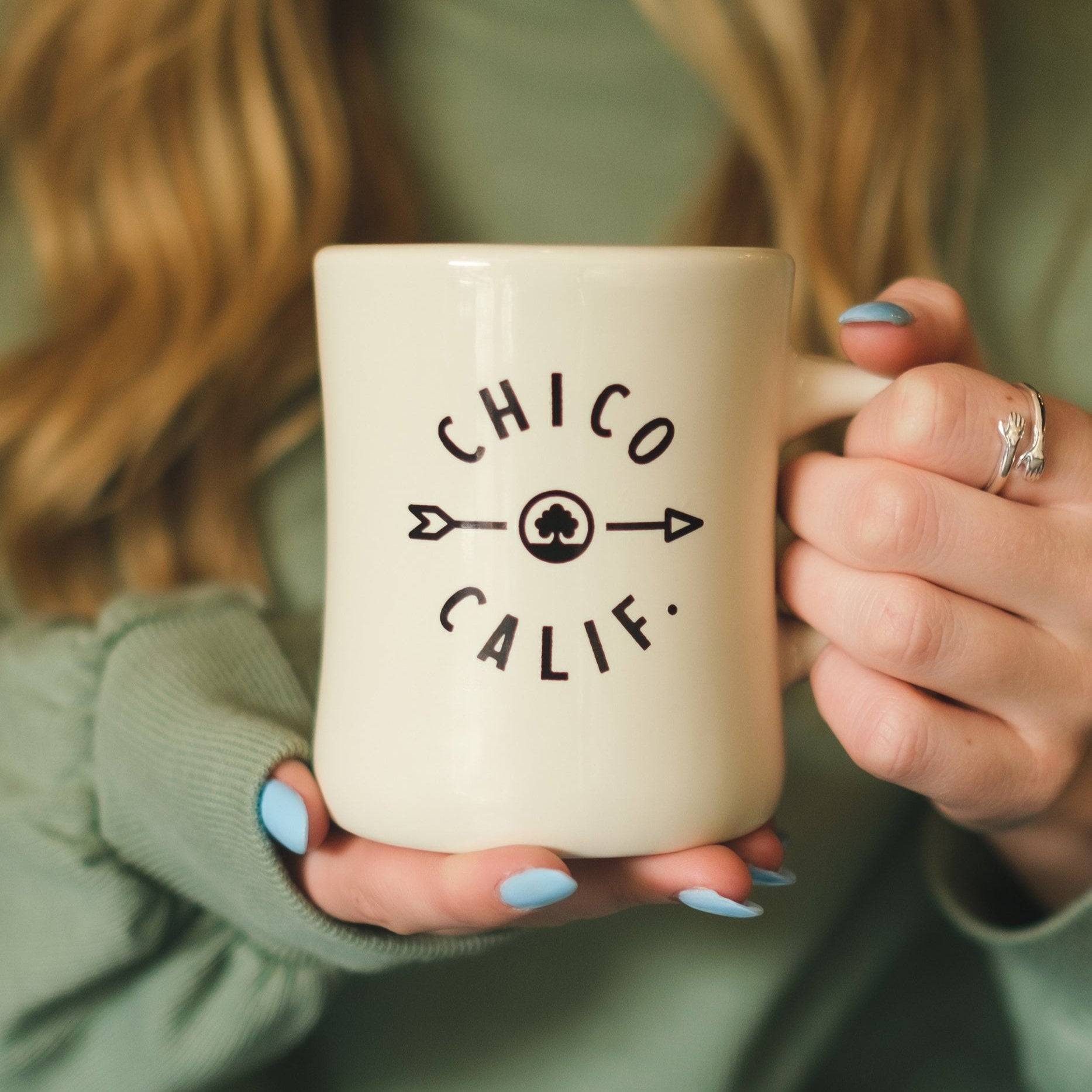 Woman holding a Native Arrow Mug from Upper Park Clothing in Chico, Ca