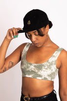 Model looking down wearing our black corduroy hat with pine tree embroidered on the front