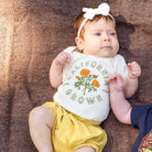 Baby wearing a California Grown Onesie from Upper Park Clothing while laying on a blanket - Chico, Ca