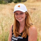 a women sitting and wearing a Upper Park Clothing California Poppy White Hat in Upper Bidwell Park Chico