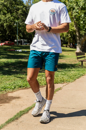 man walking at One Mile Sycamore Pool wearing a Freshwater Floating Club tee and Pro Label Beach Shorts from Upper Park Clothing 