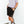 mean leaning against a white wall wearing a orchid simple mineral washed shirt and black men's stadium shorts from Upper Park Clothing