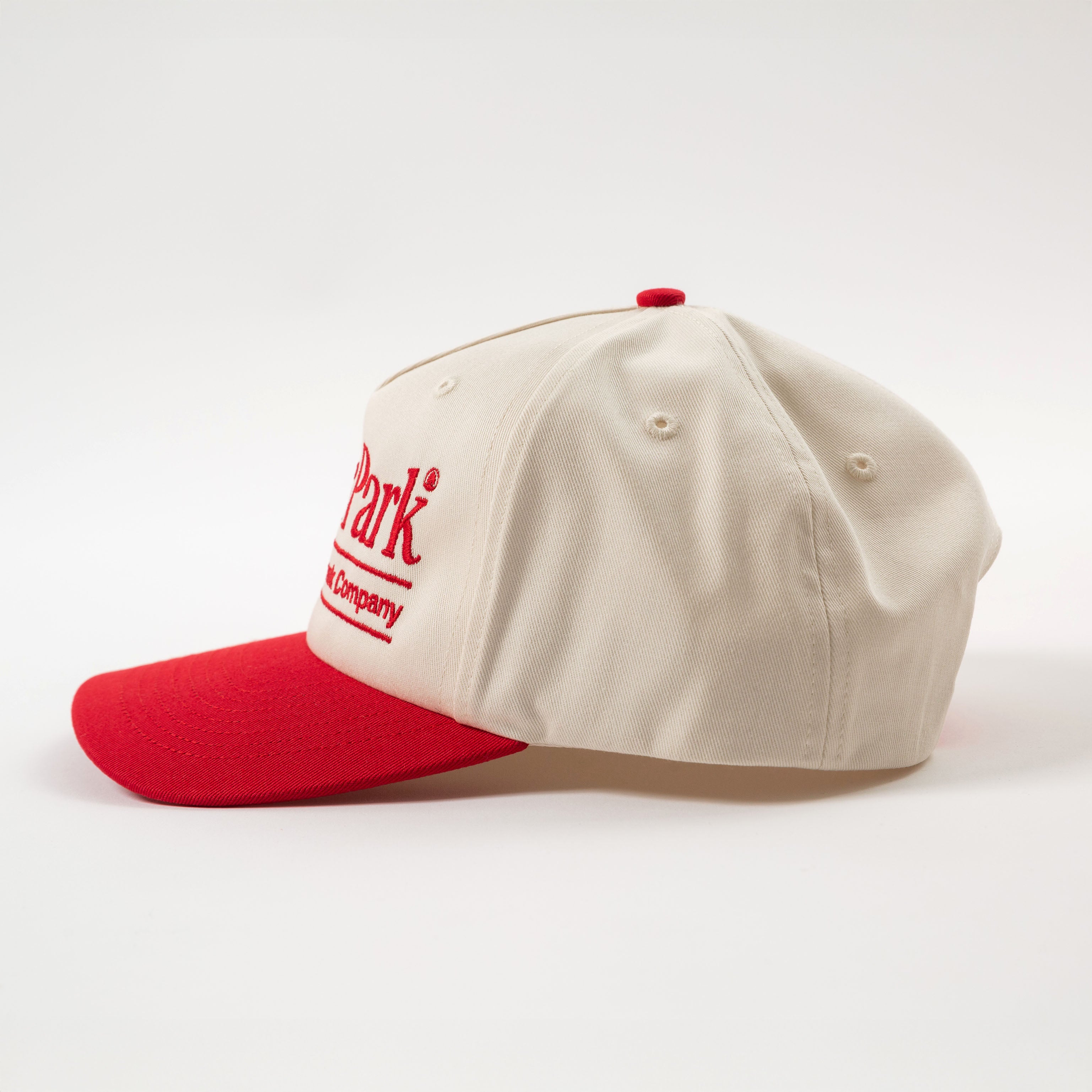 side view of vintage style baseball hat cream and red cap with a logo on a white background - California Landmark Company