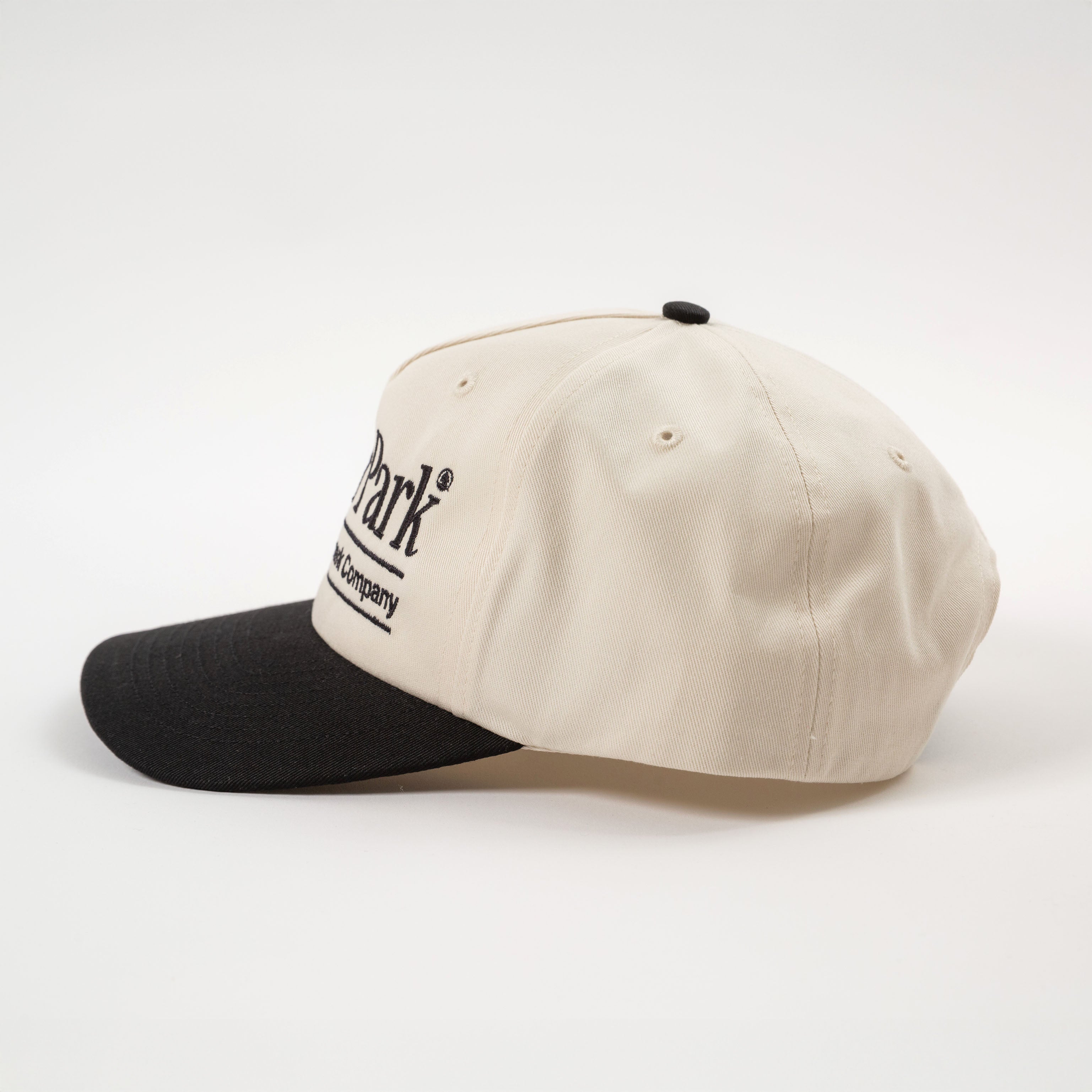 Cream and black cap with a brand logo on a white background - California Landmark Company