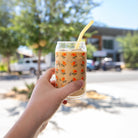 Hand holding a California Poppy Flower Beer Can Glass from Upper Park Clothing in Chico, Ca