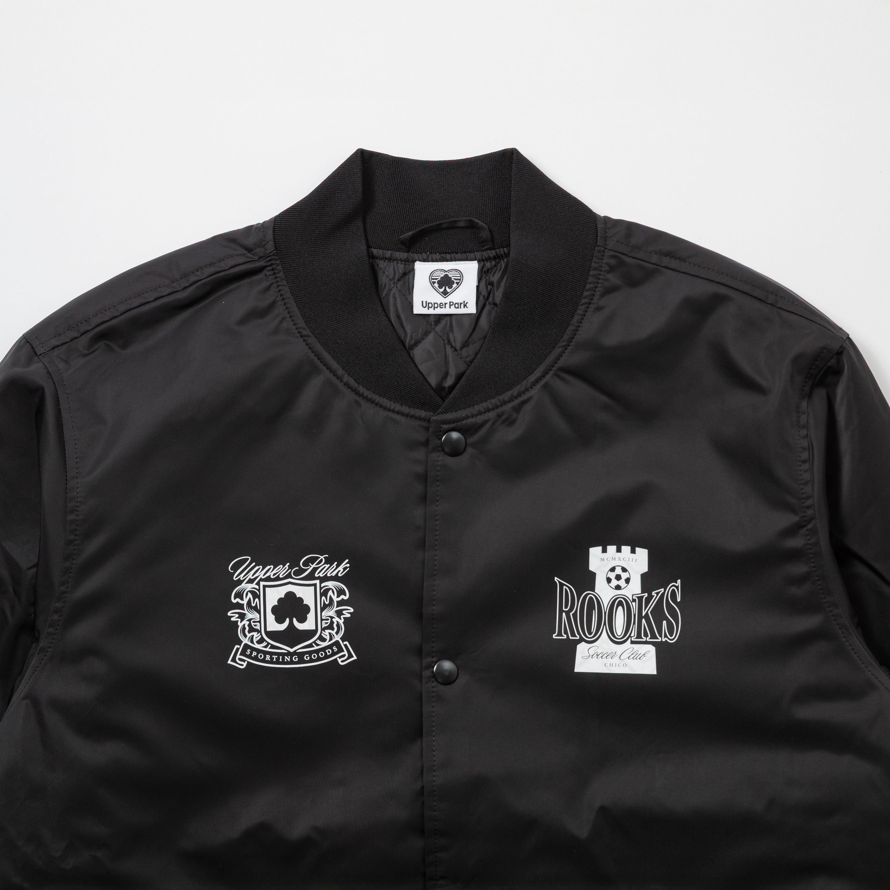 Chico Rooks Soccer Club x Upper Park Jacket - Black jacket with white logos on a light gray background