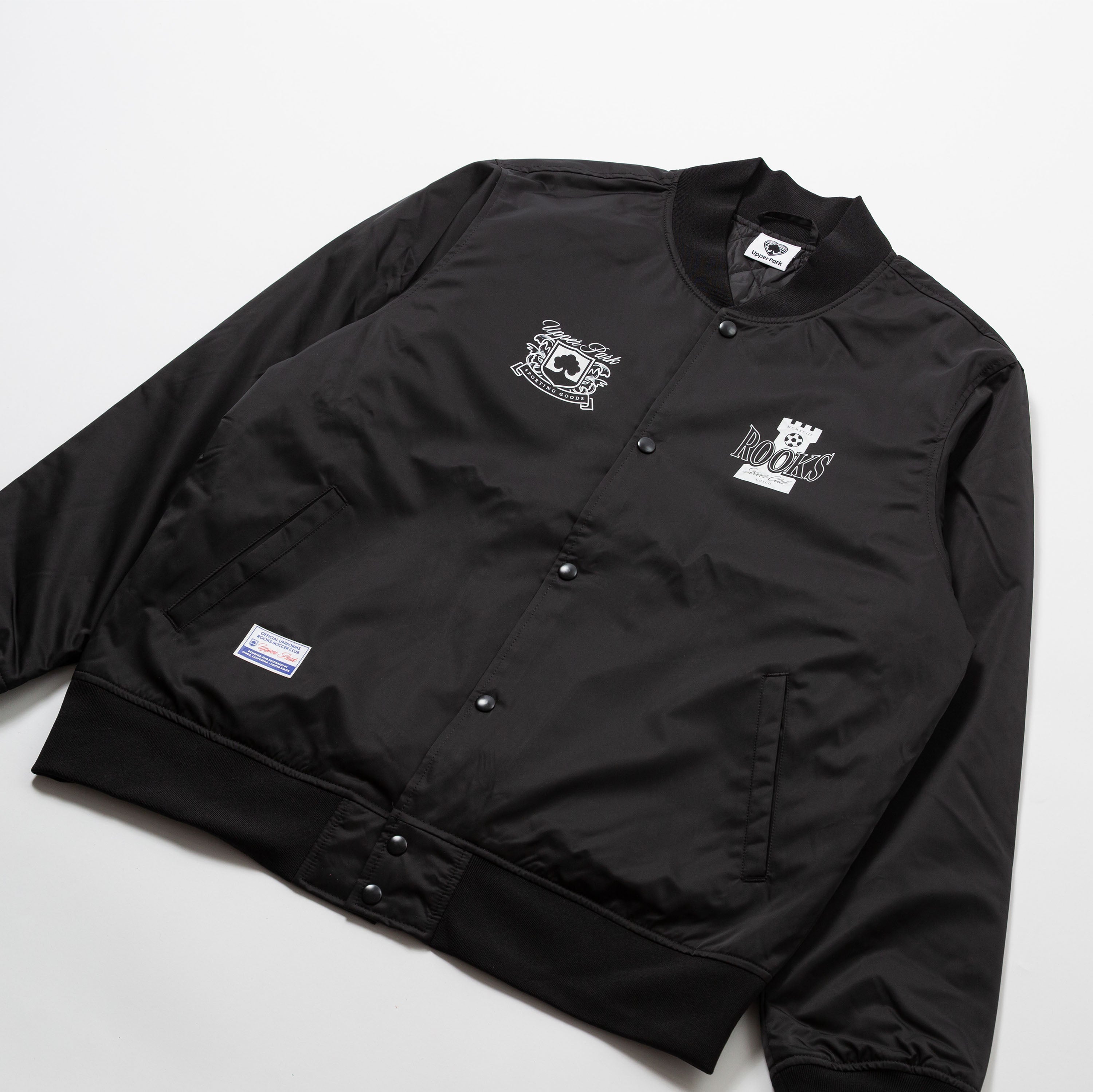 Chico Rooks Soccer Club x Upper Park Jacket - Black jacket with logos on a light gray background