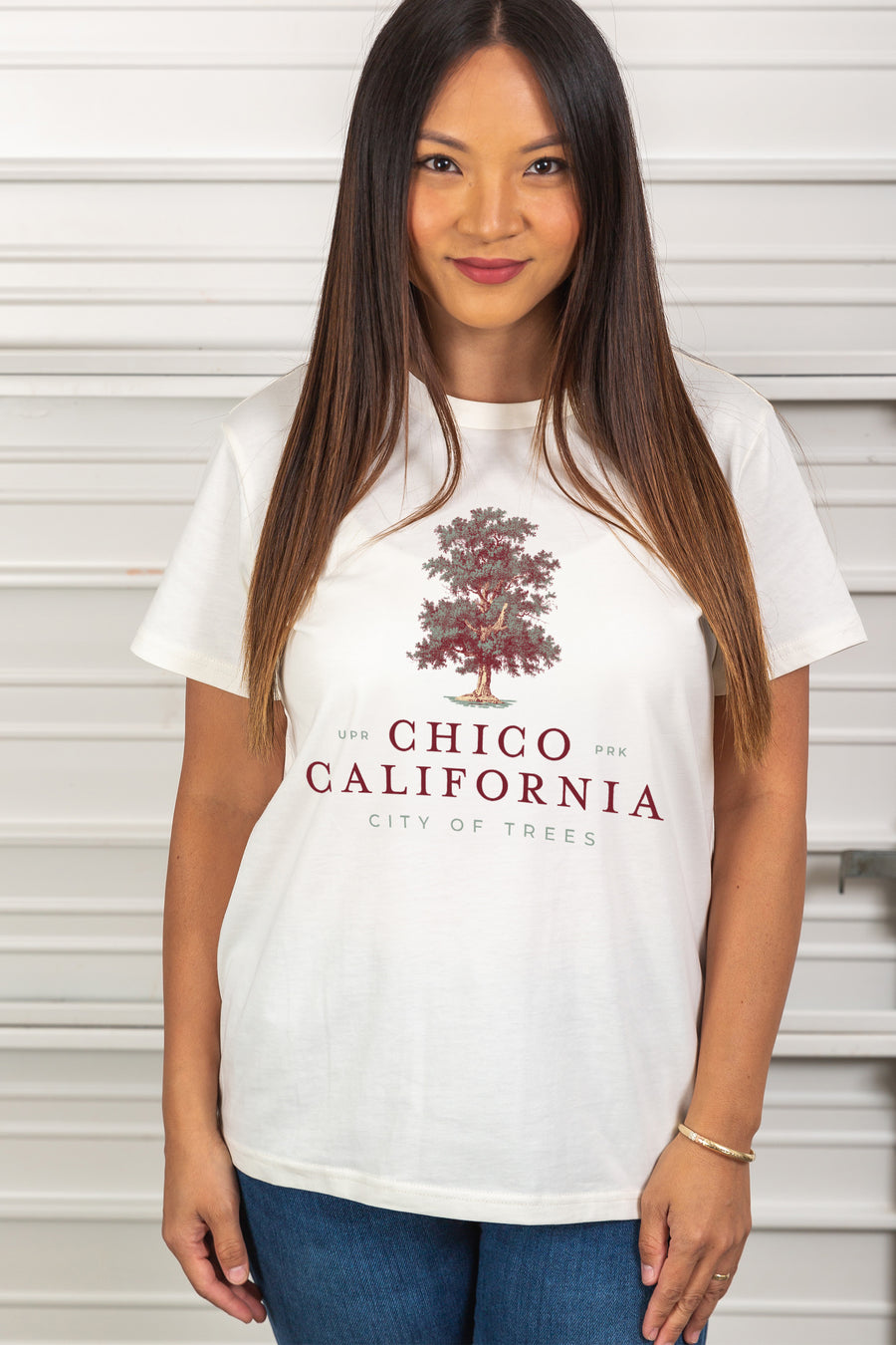 women standing in front of a garage door wearing a White Chico City of Trees Routine Tee from Upper Park Clothing