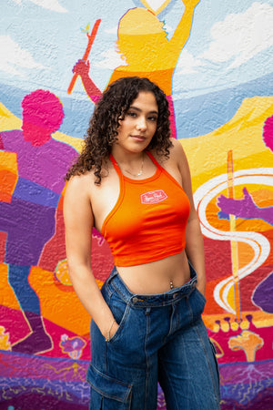 women wearing a orange halter top standing in front of a mural in Downtown Chico