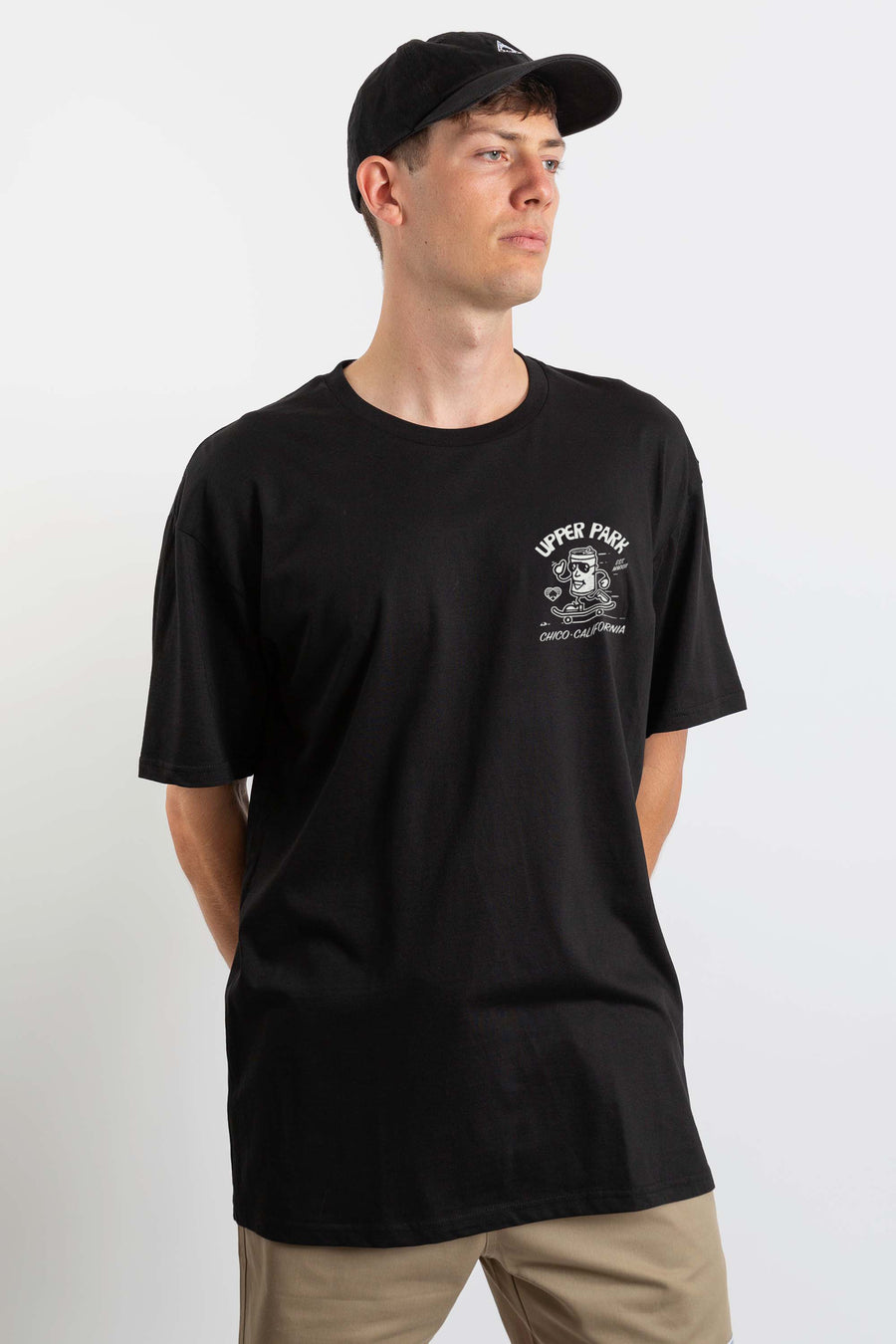 man in a photography studio wearing a Black Upper Park Clothing Corner Store Shirt