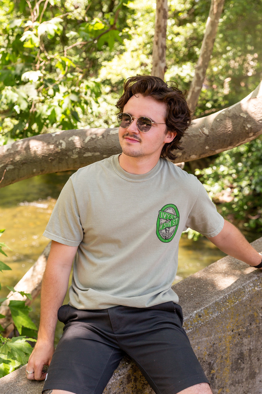 man sitting on a wall in Lower Bidwell Park wearing a Fifth and Ivy shirt from Upper Park Clothing