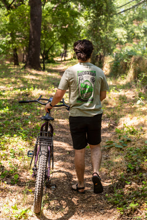 man walking his bike in Lower Bidwell park while wearing a Fifth and Ivy shirt from Upper Park Clothing
