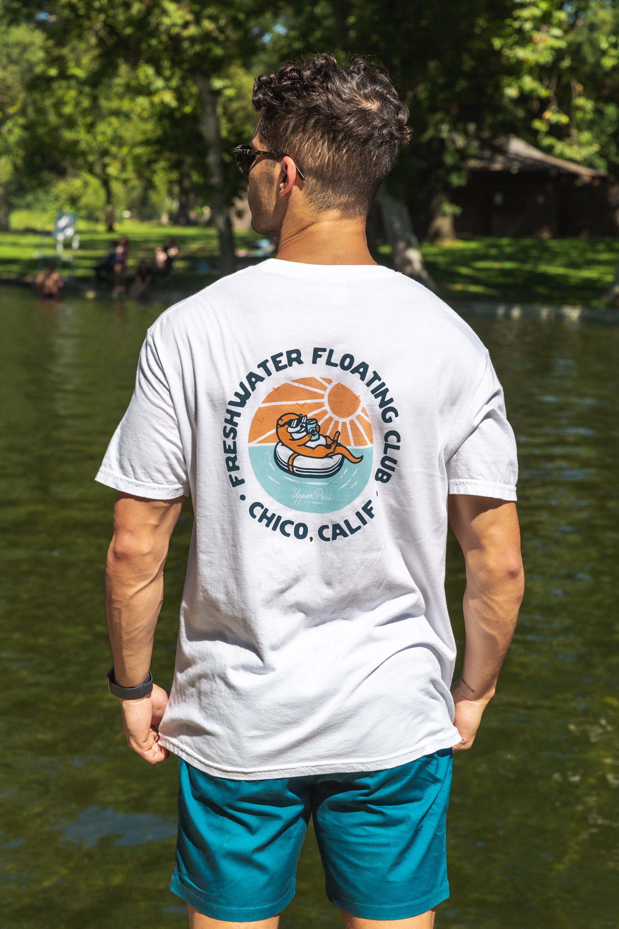 man walking at One Mile Sycamore Pool wearing a Freshwater Floating Club tee and Pro Label Beach Shorts from Upper Park Clothing 