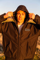 man leaning against a rail at Horseshoe Lake in Upper Bidwell Park wearing a workwear back from Upper Park Clothing