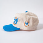 Beige cap with blue brim and logo on a white background - Rally Unstructured Vintage Style Hat