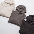 Relax oversize hoodie garment dyed - Three folded hoodies in beige, gray, and black on a light gray background