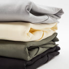 Stack of folded hoodies in gray, yellow, green, and black on a white background - Upper Park Athletics Hoodie Set