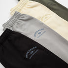 Four pairs of pants in black, gray, yellow, and green with 'Upper Park' branding - Upper Park Athletics Sweatpants Set
