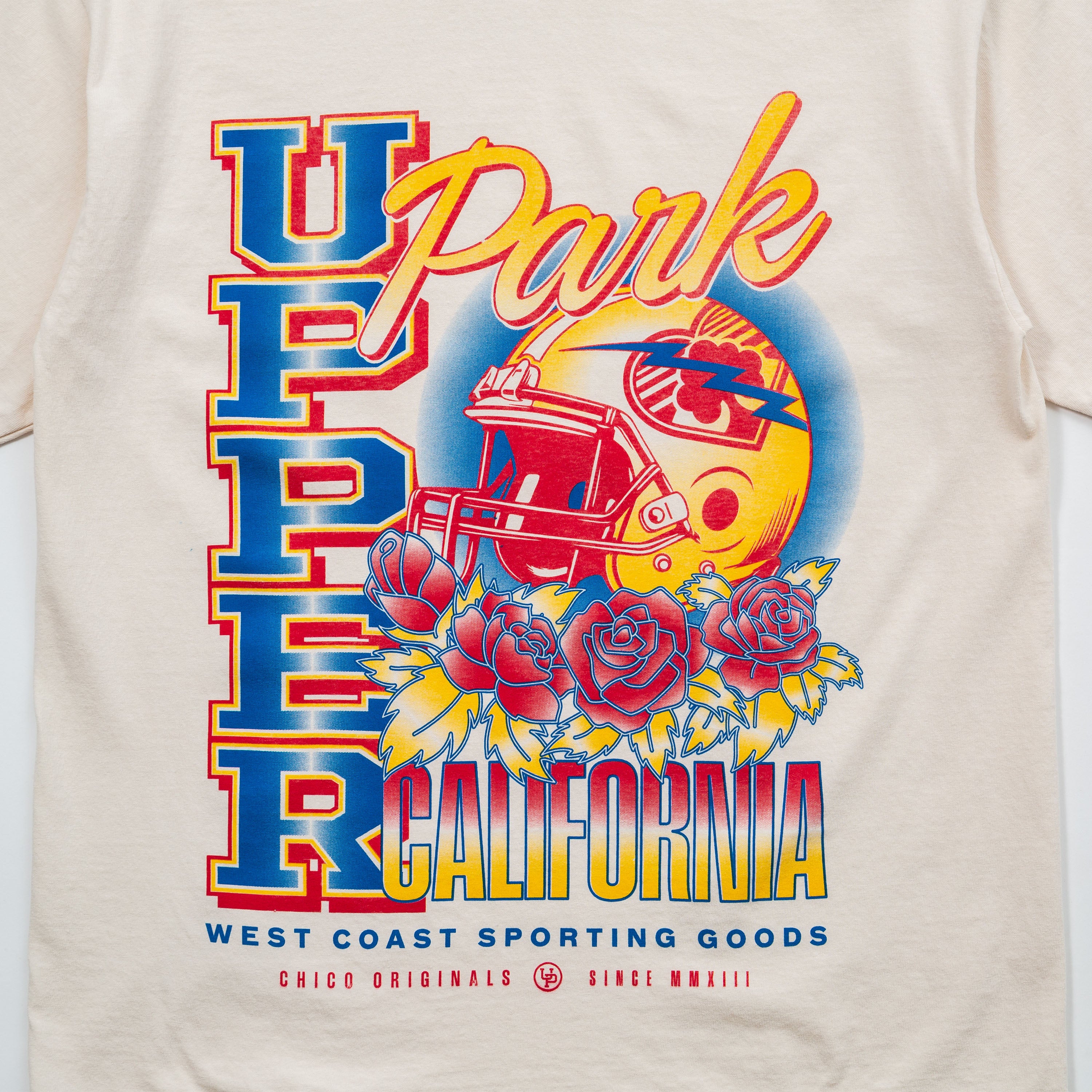Upper Park Varsity Rose Football Tee - Beige t-shirt with colorful graphic design featuring text and sports-themed elements.