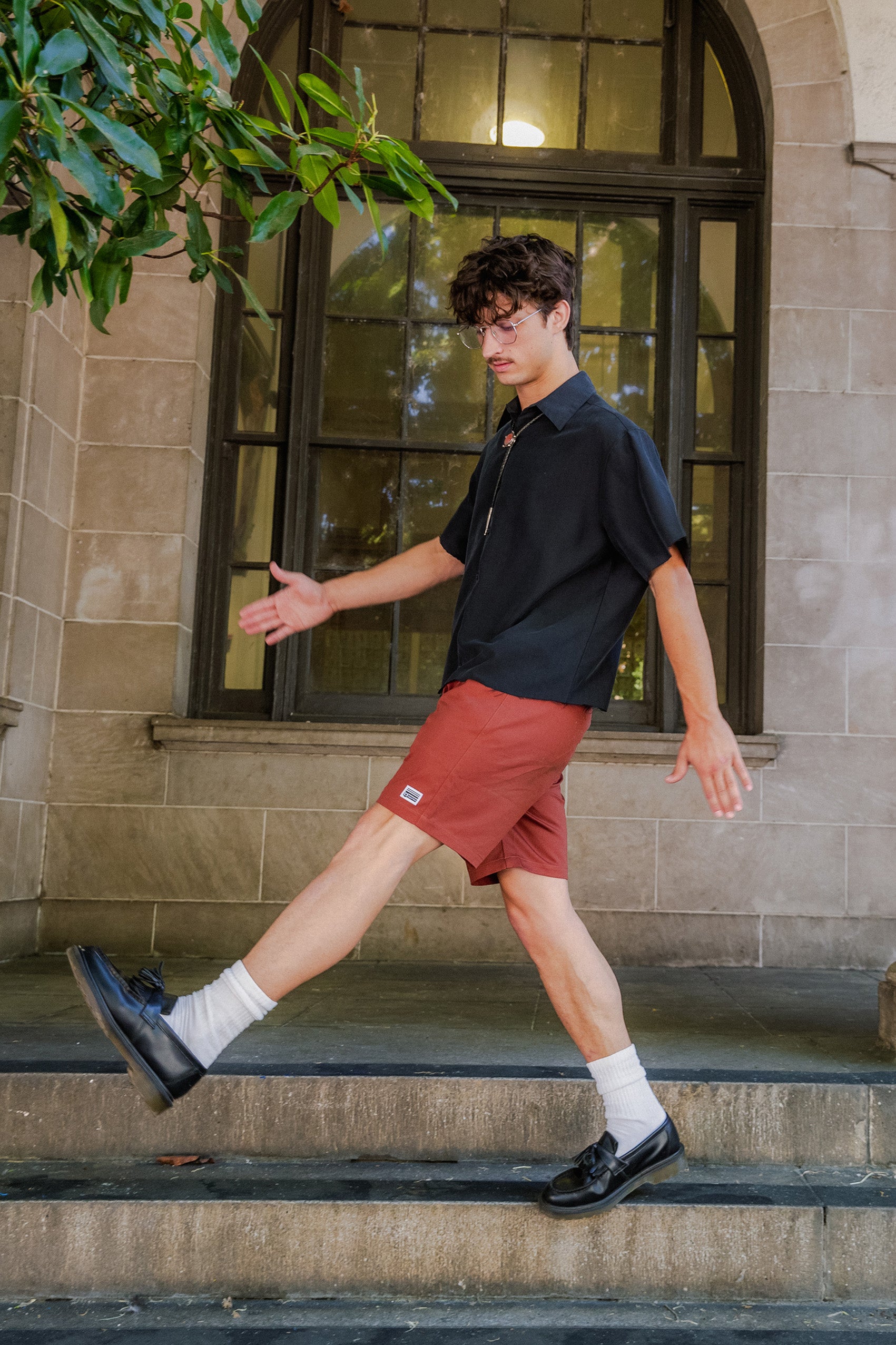 man standing on the stairs in front of the U.S Post Office in Downtown Chico wearing clay walk shorts from Upper Park Clothing