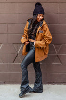 women standing in front of a blank wall in Downtown Chico wearing a workwear jacket from Upper Park Clothing