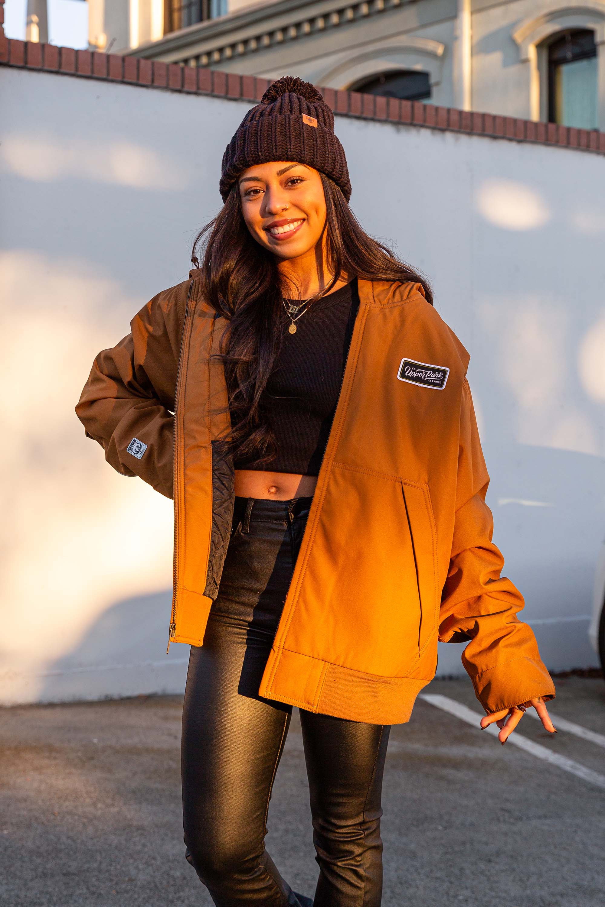 women standing in front of a blank wall in Downtown Chico wearing a workwear jacket from Upper Park Clothing