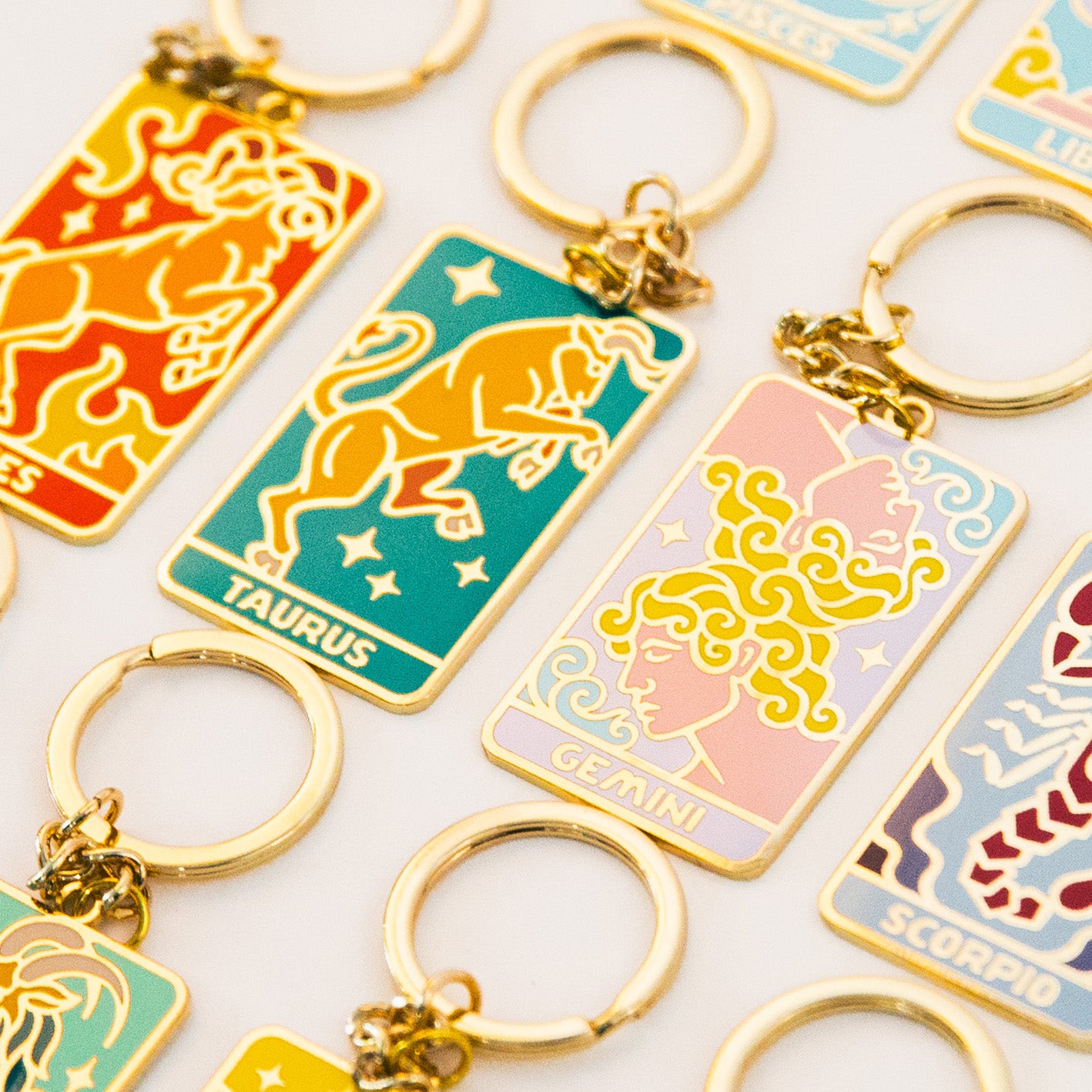 Collection of zodiac keychains on a light background - Detail of Taurus, Gemini, Scorpio