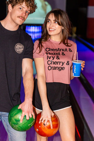 man and women standing in front of the bowling lanes in Chico wearing a mauve colored crop tee from Upper Park Clothing